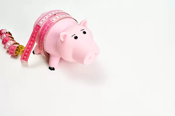 Piggy bank with measurement tape - Concept of economy and money diet