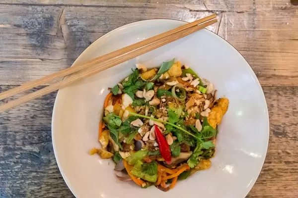 Pikantes veganes Gericht des Chum Chay vietnamesischen Restaurants in Köln: Bio-Tofu mit Zwiebeln, Pak-Choi, Champignons, Zuckererbsen und Erdnüssen in Limetten-Chili Sauce