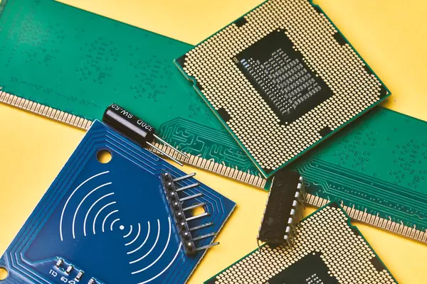 Pile of integrated circuit chips and semiconductors on yellow background - Global microchip shortage