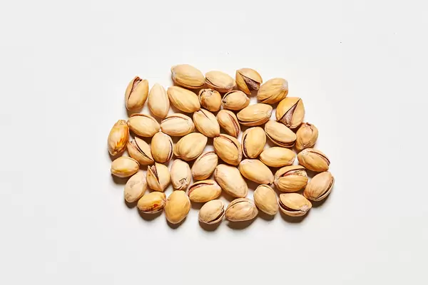 Pile of pistachios in the peel on a white background
