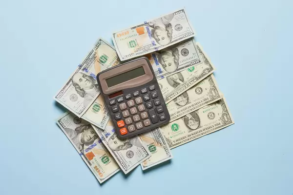 Pile of us dollar banknotes and calculator