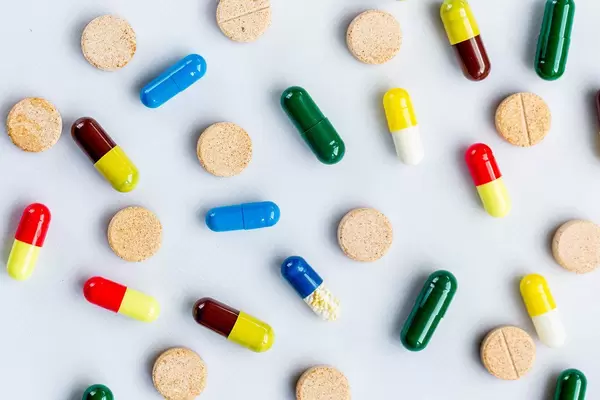 Pills and capsules of different colors. Top view