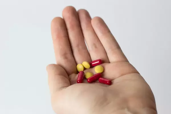 Pills on mans hand
