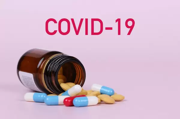 Pills poured out of bottle with COVID-19 text