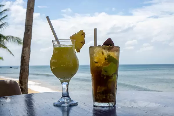 Pina Colada with Fresh Pineapple and Passion Fruit Mojito with Mint, Lime and Ice Cubes in Cocktail Glasses on a Table at a Beach Bar in Phu Quoc, Vietnam