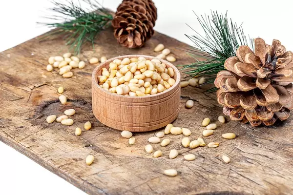 Pine nuts with pine cones and branches on an old kitchen Board (Flip 2020)