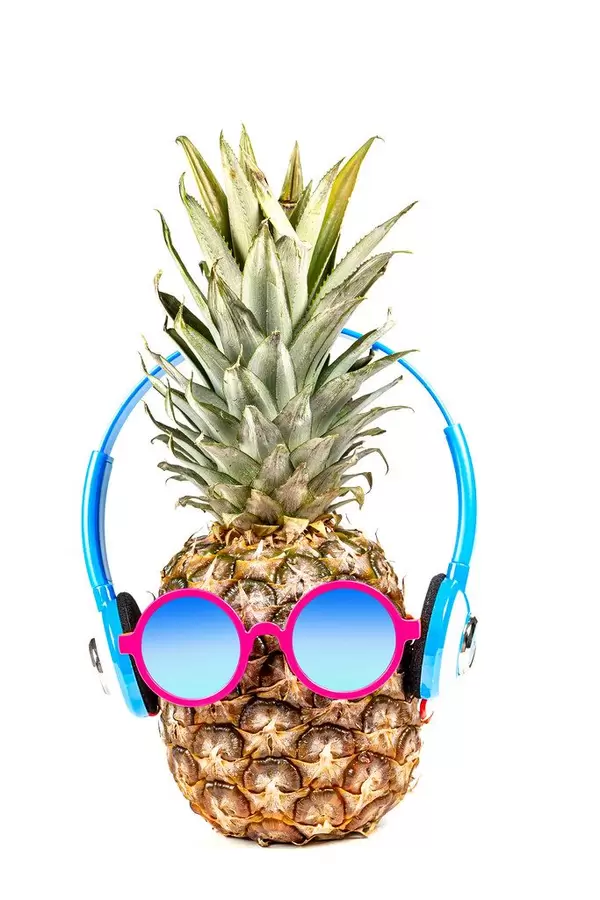 Pineapple wearing sunglasses and headphones. Concept of summer vacation, recreation (Flip 2020)