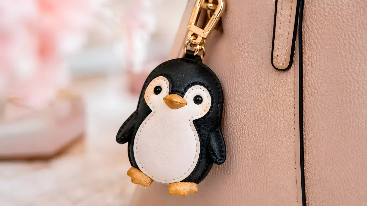 Pinguin-Taschenanhänger aus Leder an rosa Handtasche