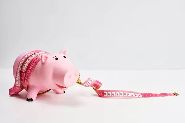 Pink piggy bank tied with tape - a symbol of the crisis