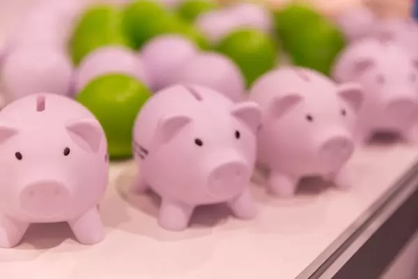 Pink piggy banks and colorful balls in the background
