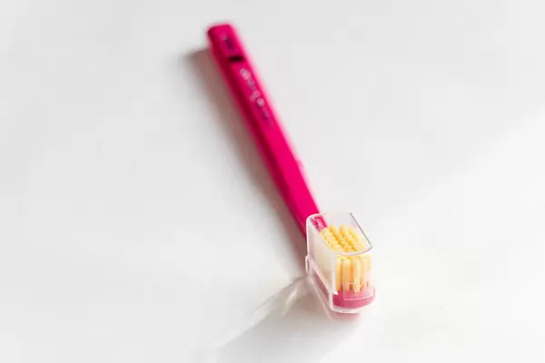 Pink wooden toothbrush on a white background