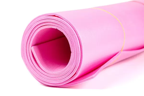 Pink yoga mat for exercise on white background