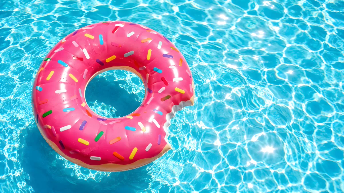 Pinker Donut-Schwimmring mit Streuseln im Pool