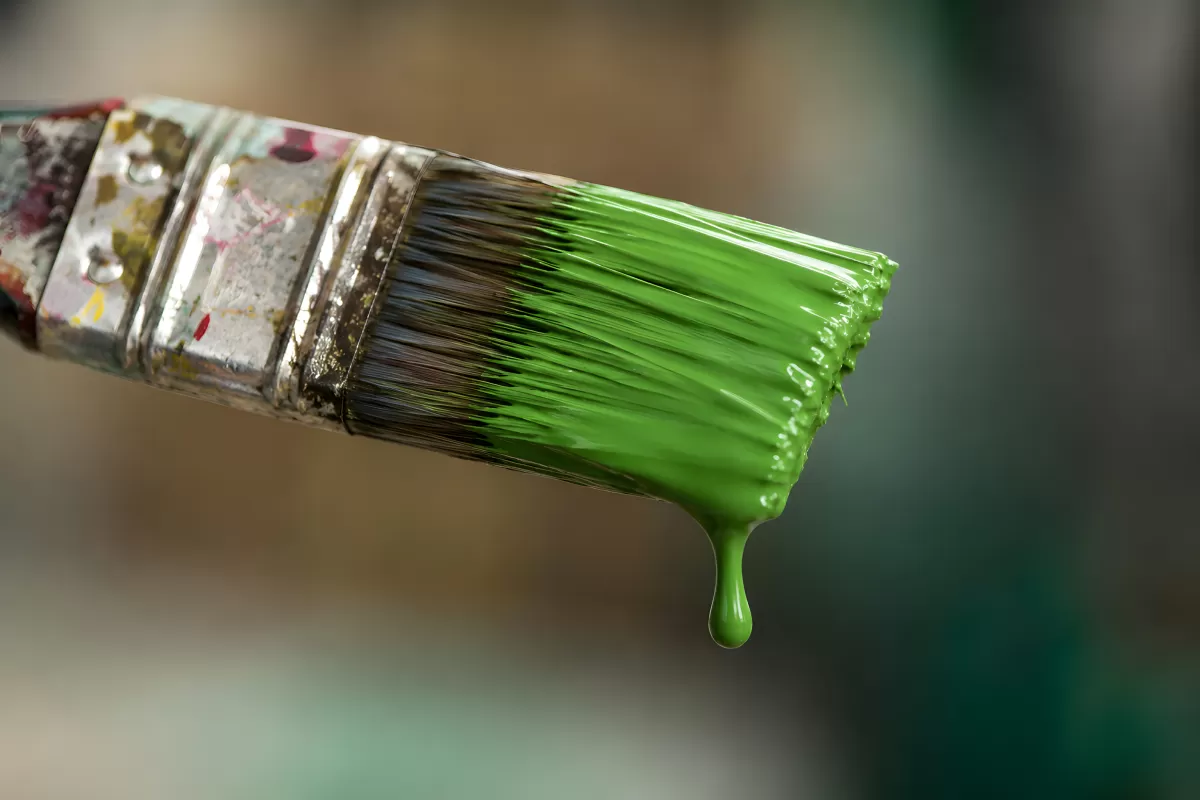 Pinsel mit grüner Farbe tropft im Nahaufnahme