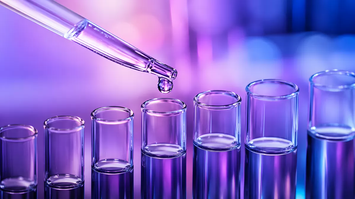 Pipette tropft Flüssigkeit in Reagenzgläser im Labor