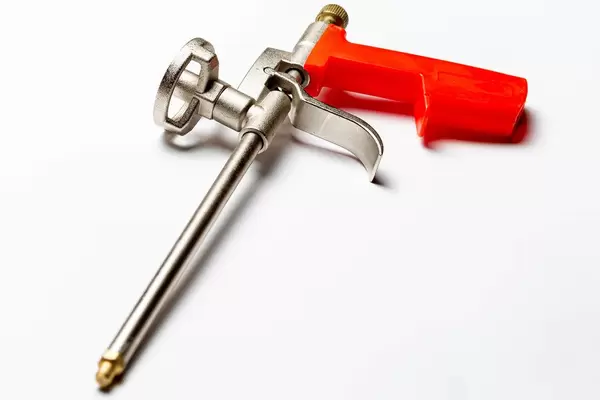 Pistol for adhesive foam on white background (Flip 2020)