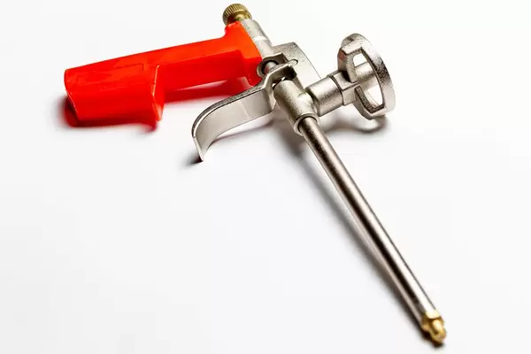 Pistol for adhesive foam on white background