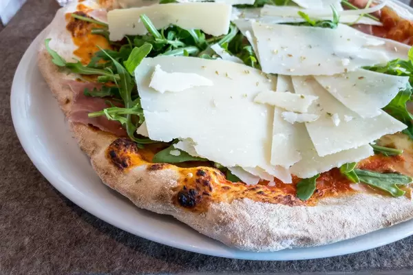 Pizza mit Parmesan, Rucola und Parmaschinken