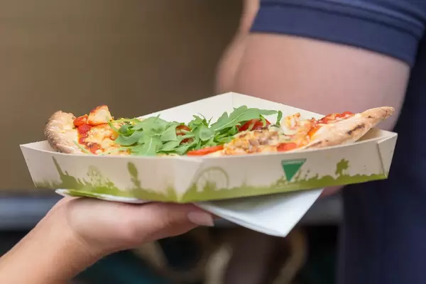 Pizzastück mit Rucola auf kompostierbarem Pappteller von Essensstand am Tomorrowland 2019