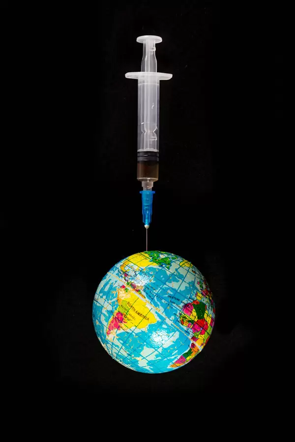 Planet earth on a needle of a medical syringe on a black background