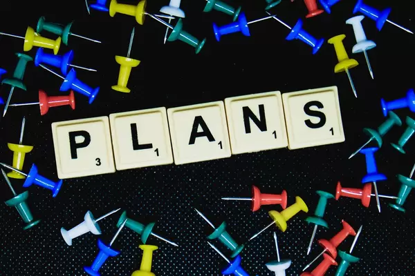 Plans text with pins on black background