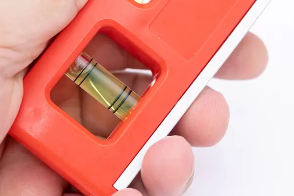 Plastic Level with Bubbles in the hand isolated above white background