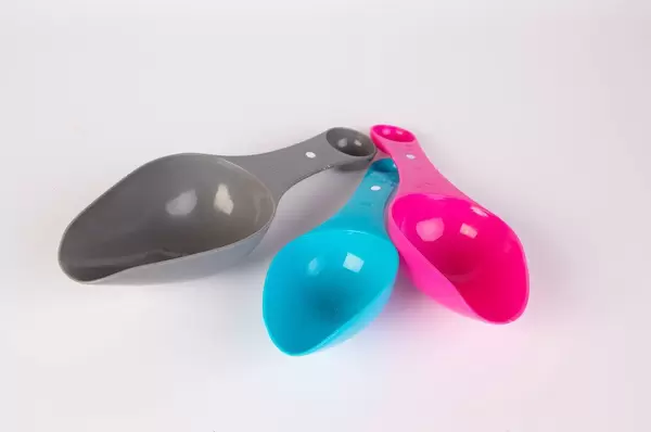 Plastic measuring spoons on white background