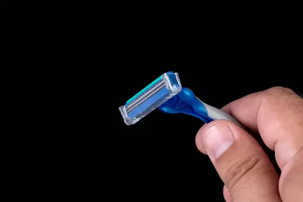 Plastic Razor in the hand above black background (Flip 2019)