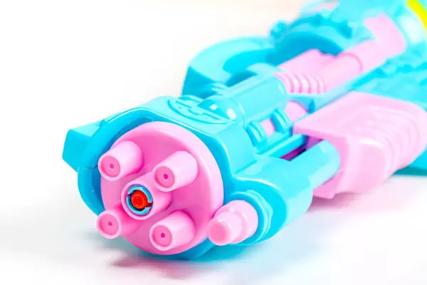 Plastic water gun over white, closeup