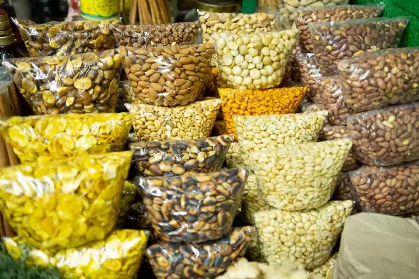 Plastikbeutel mit verschiedenen, in Plastikbeuteln abgepackten Kernen, Nüssen und Samen an einem Marktstand