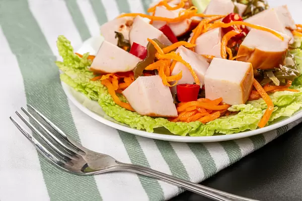 Plate with salad from carrots, lettuce, seaweed, chicken and chili