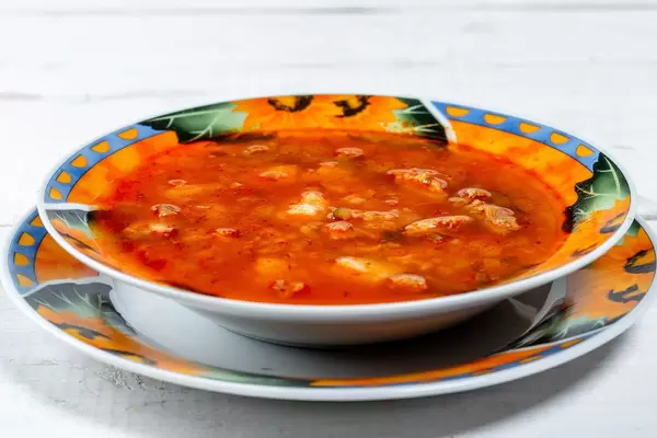Plate with soup-pickle on a white background