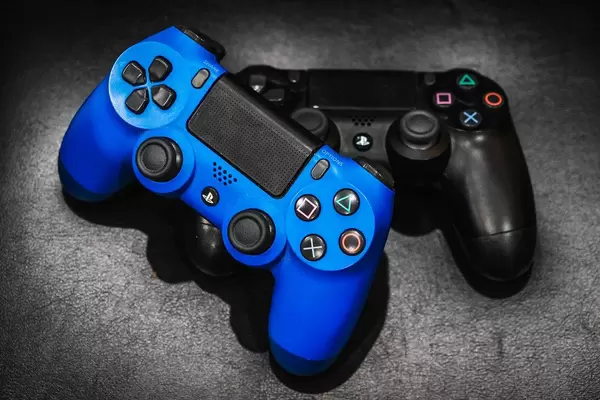 Playstation controllers on black foam surface