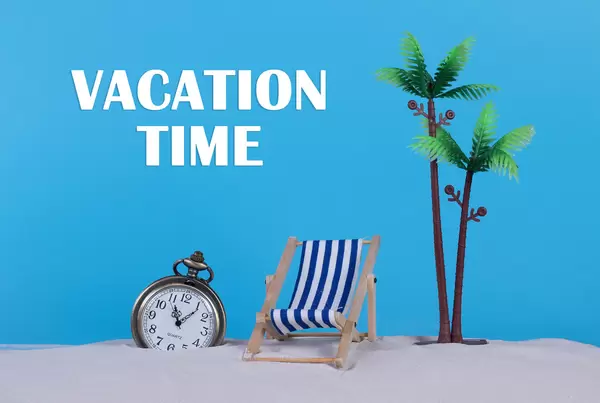 Pocket watch and beach chair with Vacation Time text on blue background