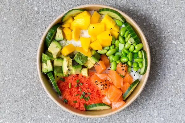 Poké Bowl Lachs: Reisschale mit Mango, Masago, Sojabohnen, Gemüse. Aufnahme von oben
