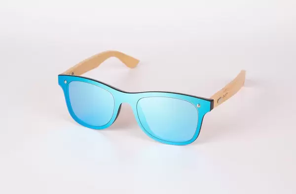 Polarisierte Sonnenbrille von Oley aus Holz mit blauem Rahmen und Gläsern auf weißem Tisch