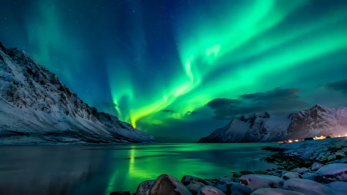 Polarlichter über verschneitem Fjord in Nordnorwegen