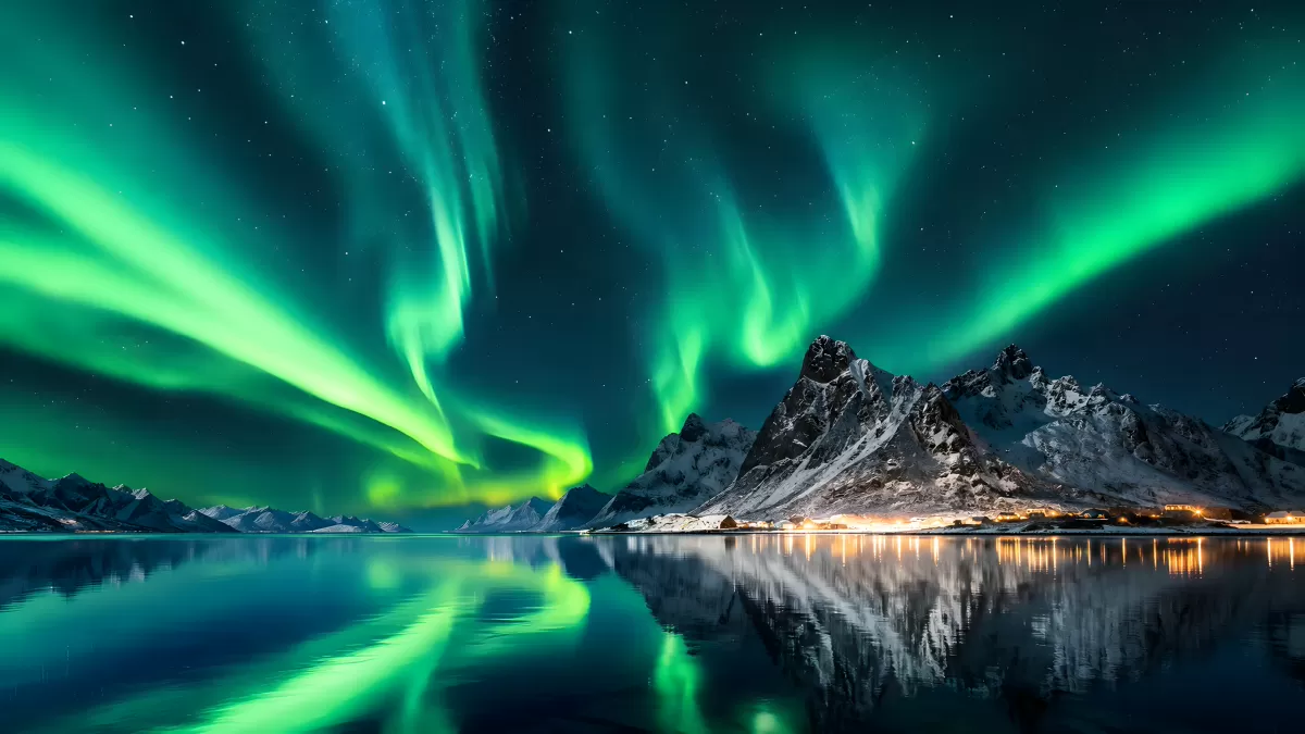 Polarlichter über verschneiten Bergen am Fjord