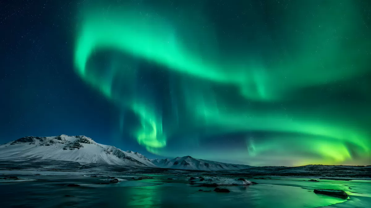 Polarlichter über verschneiter Berglandschaft Island