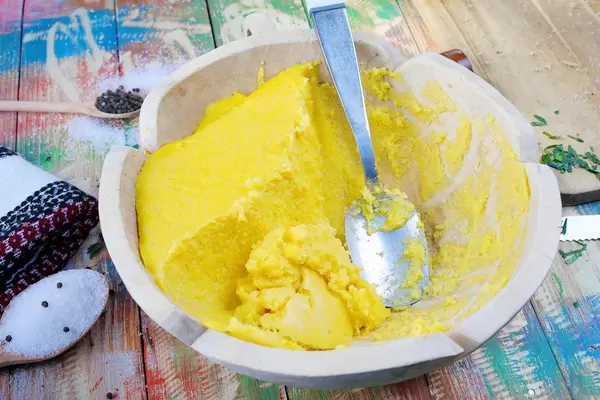 Polenta in einer hölzernen Schüssel auf einem Tisch im Country-Stil