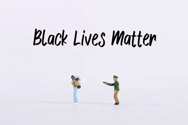 Policeman pointing a gun into a man with Black Lives Matter text