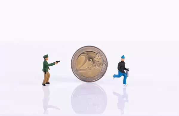 Policeman, robber and 2 Euro coin on white background