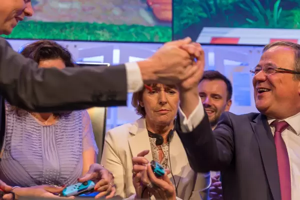 Politiker spielen Super Mario Party auf der Gamescom. Hans und Laschet schütteln Hände nach einer Partie Super Mario Party