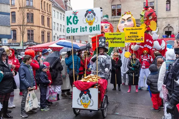 Politischer Karnevalszug am Rosenmontag in Köln mit Attac-Aktivisten & Figuren von Andi Scheuer (Andi B. Scheuert), der Jungfrau Vonovia & Prinz Narrenkappetalismus