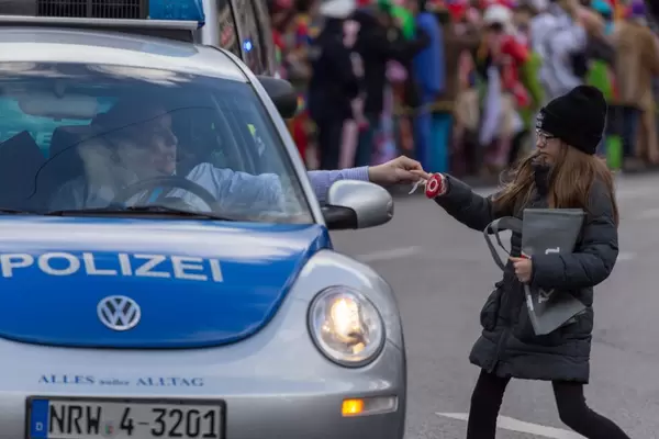 Polizeibeamter gibt einem Mädchen einen Lutscher - Kölner Karneval 2018