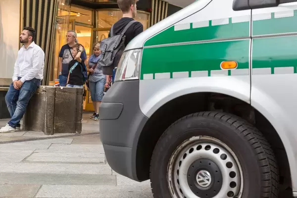 Polizeiwagen und Passanten im Hintergrund