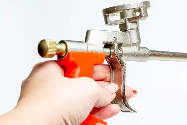 Polyurethane gun in hand on white