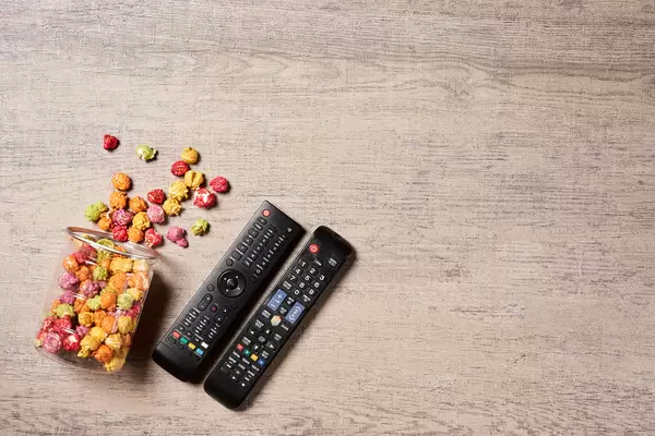 Popcorn and remote control for TV - leisure and entertainment of watching cinema