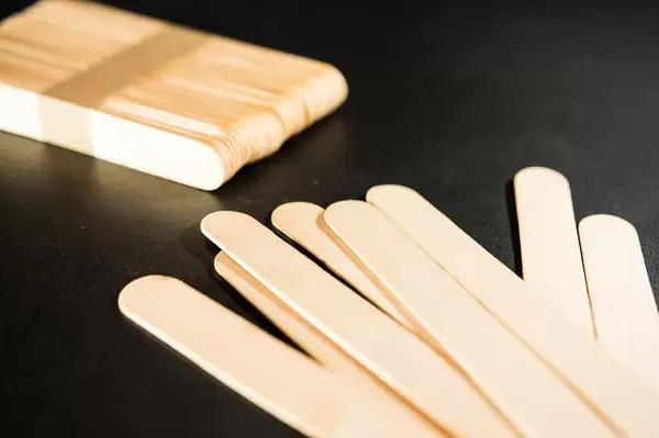 Popsicle craft sticks on a black surface