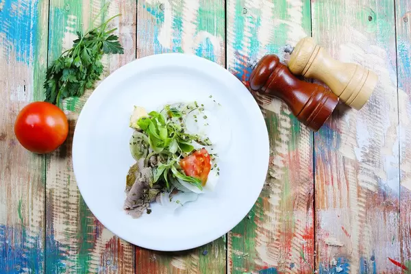 Pork steak with fresh tomato in white plate. Wooden vintage background (Flip 2019)